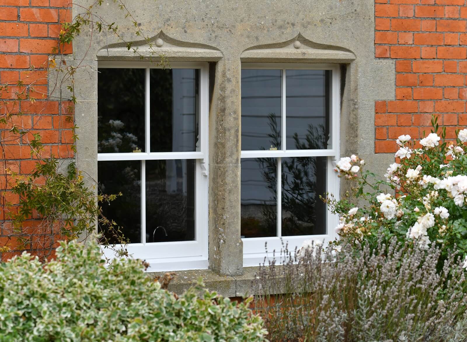 Traditional 2-over-2 sash windows with stone surround
